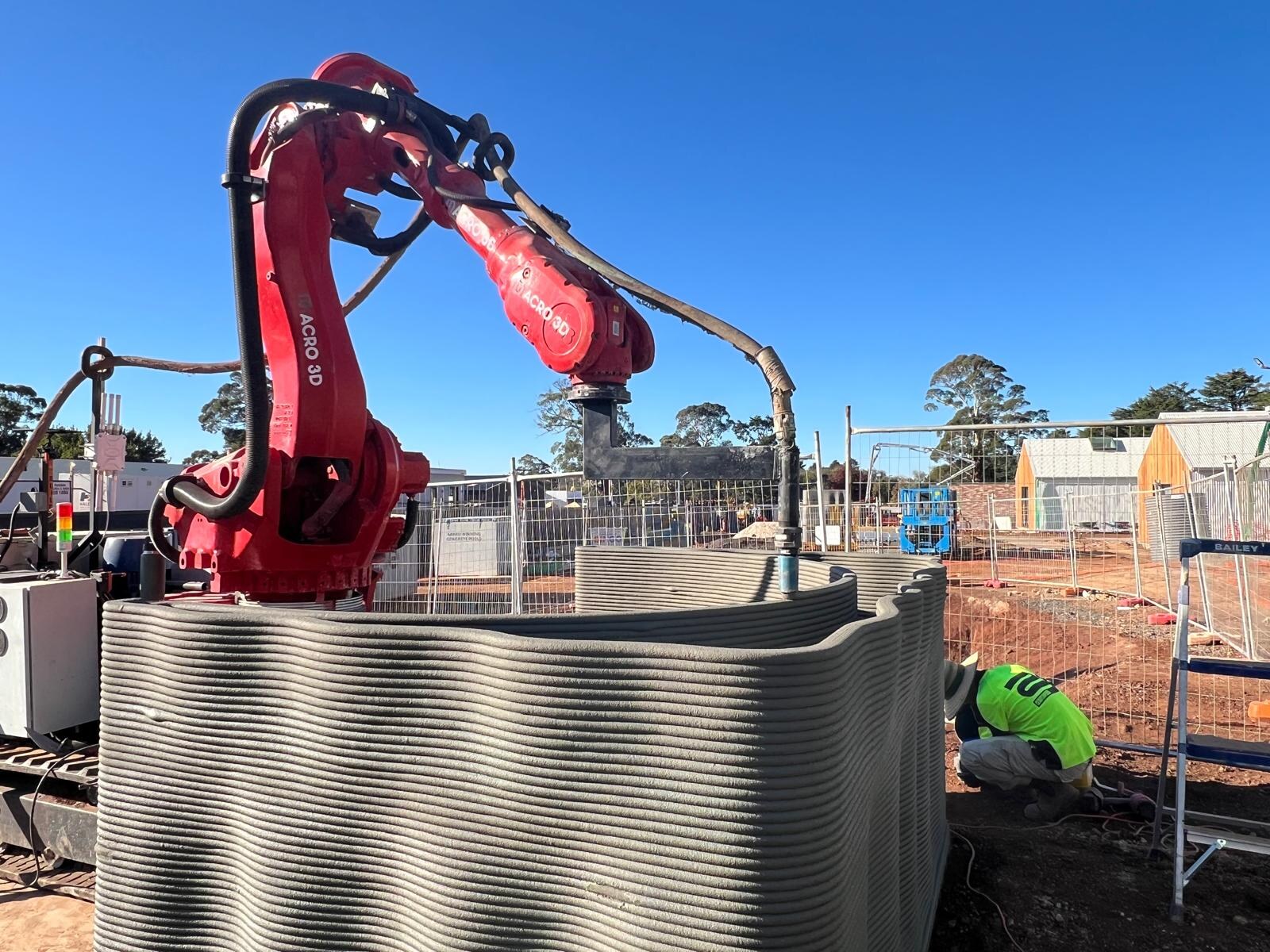 Macro3D red robot printing a wall section on site